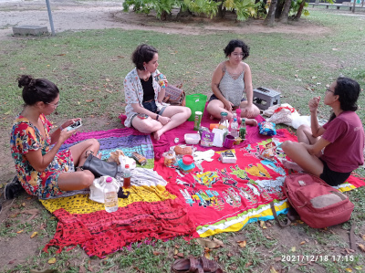 Grupo de 4 mujeres comiendo sentadas en un jardin